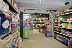Gemüseecke sowie Regale mit Getränken, Knabbereien und Haushaltsartikeln im Grabners Supermarkt.